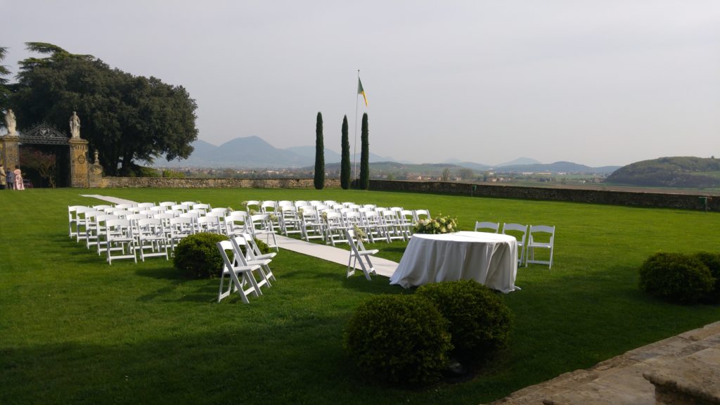 Allestimento per cerimonia nuziale con sedie bianche per gli invitati e un piccolo altare per gli sposi nel prato di fronte alla Facciata della Villa di Montruglio.