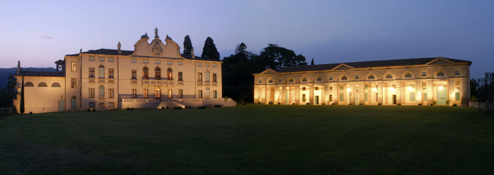 Vista notturna della Villa di Montruglio, della sua Facciata e della Barchessa illuminate, con l'ampio giardino di fronte.