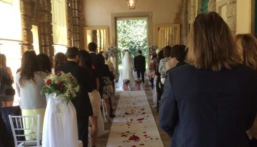 Cerimonia di matrimonio civile con invitati e sul fondo la coppia di sposi, sotto il portico della Barchessa della Villa di Montruglio.