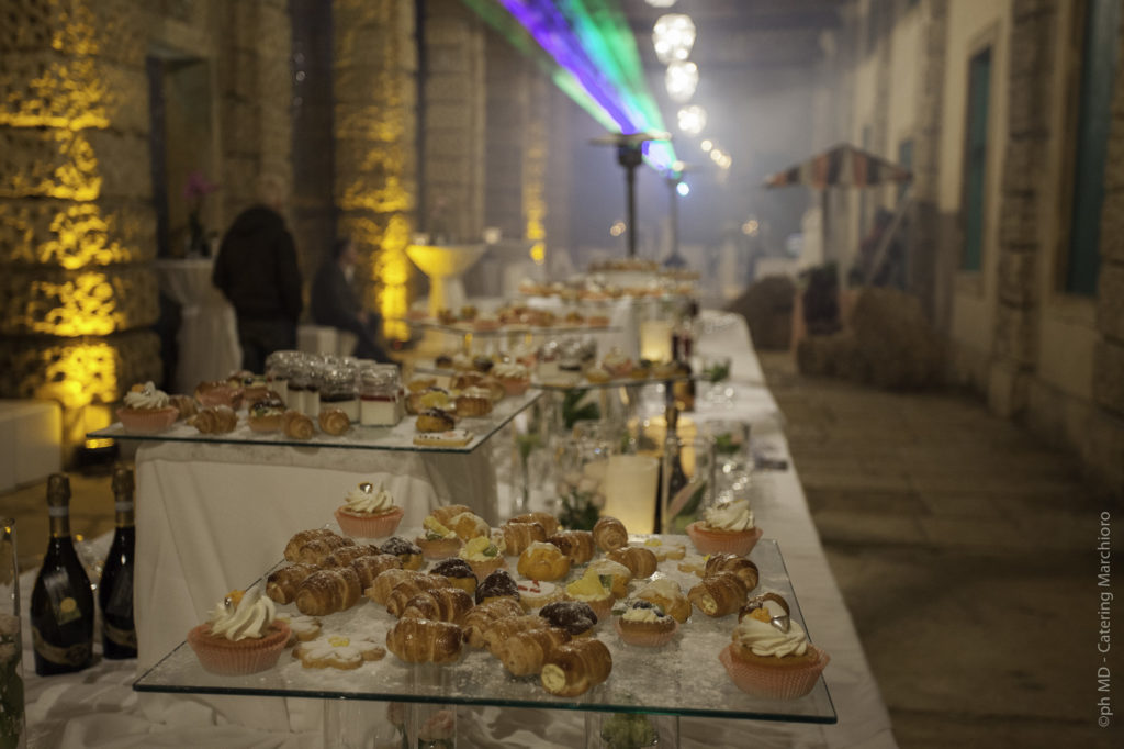 Buffet di nozze a Villa di Montruglio, con pasticcini su piatti di vetro in diversi piani.