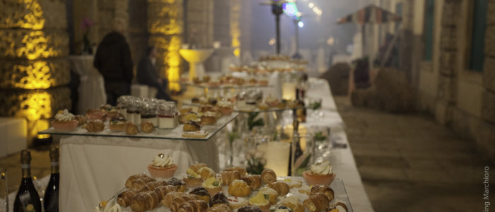 Buffet di nozze a Villa di Montruglio, con pasticcini su piatti di vetro in diversi piani.