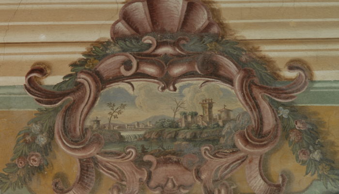 Dettaglio di una parete affrescata della Villa di Montruglio, con un paesaggio di un Castello racchiuso in una decorazione ed in un festone dipinto