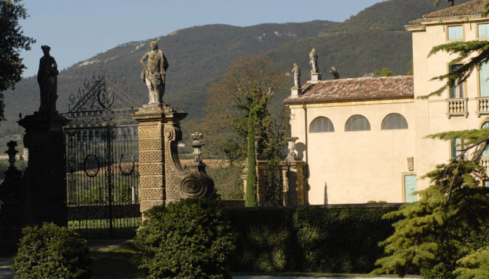 Vista laterale della Cappella gentilizia della Villa di Montruglio con cancellata e siepe.