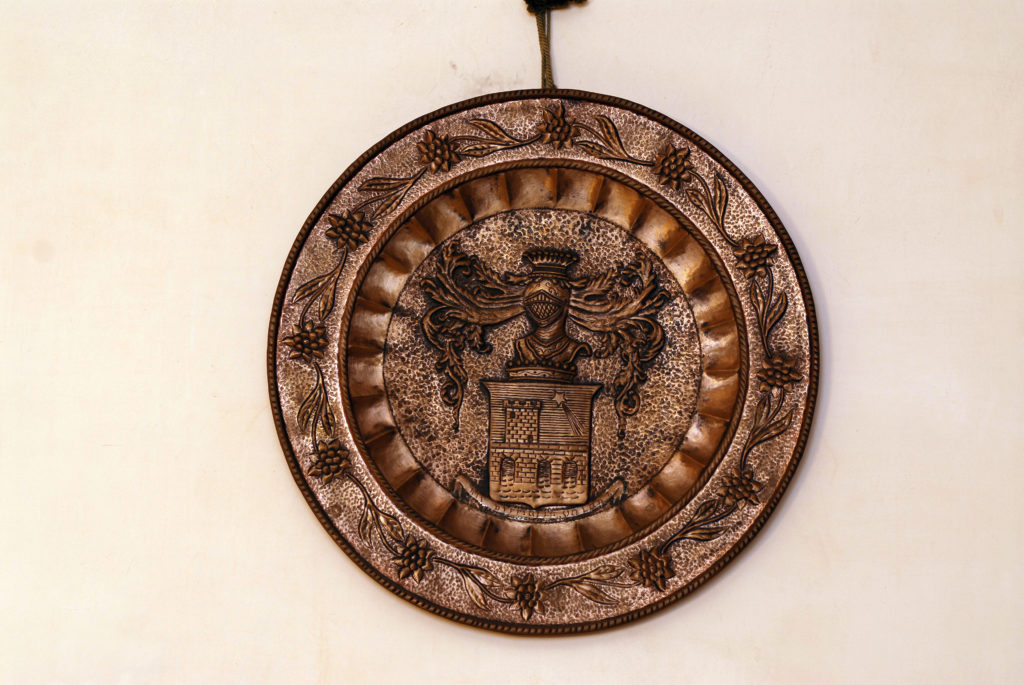 Medaglia bronzea raffigurante tematiche storiche e decorazioni.
